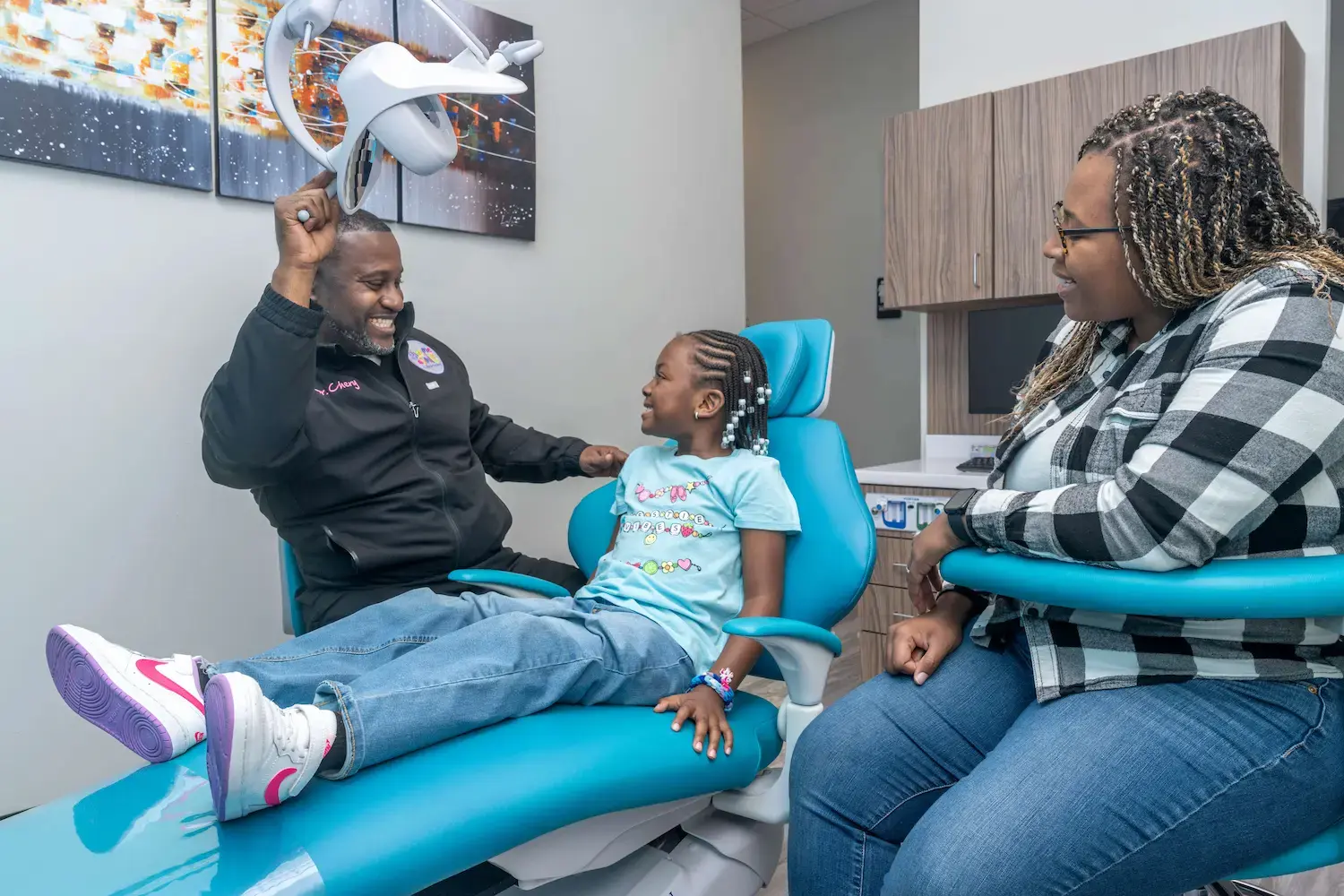 Dr. Chery putting a young patient at ease with her mom nearby
